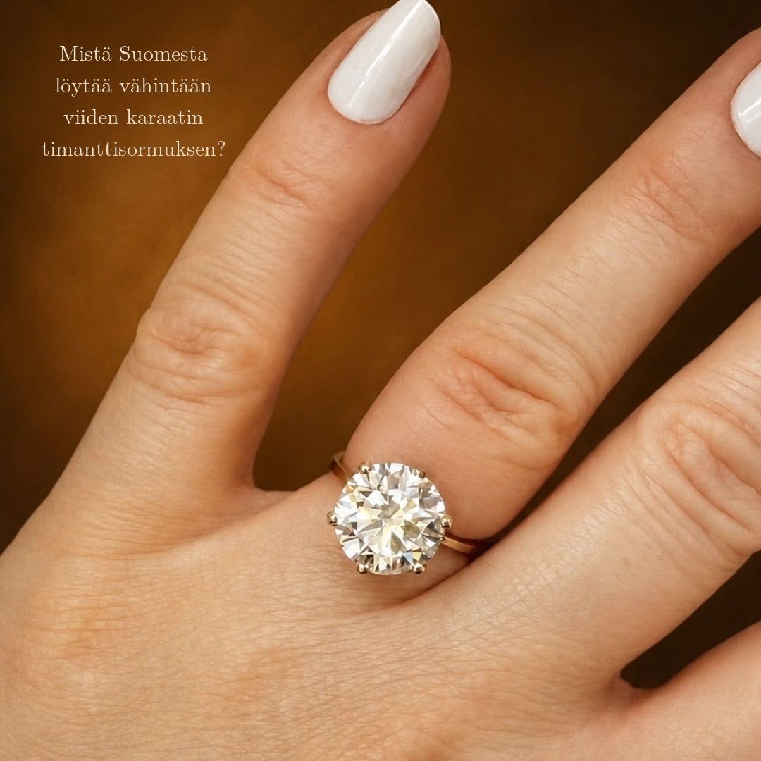 5ct Solitaire timanttisormus sormessa. Kuvan yhteydessä on teksti, jossa kysytään että "Mistä löytää vähintään viiden karaatin timanttisormuksen?