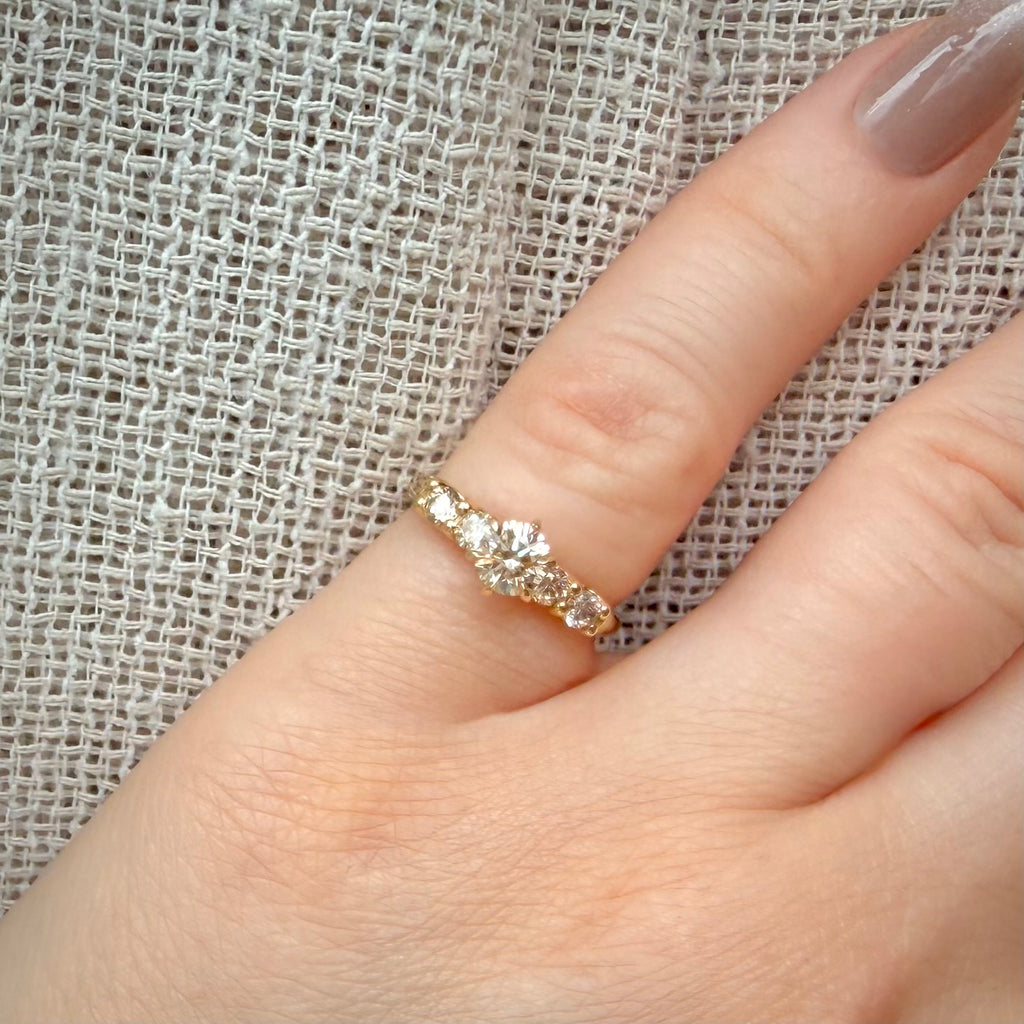 0,85 ct viisikivinen luonnontimanttisormus – 14K keltakulta – IGI sormessa pellavataustalla
