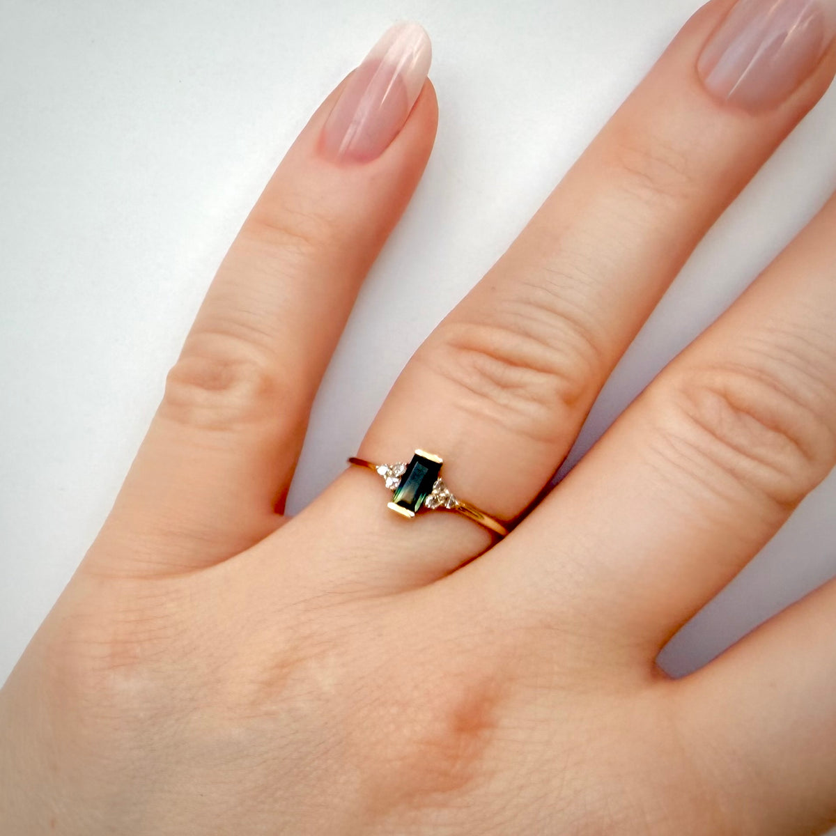 Kaksivärinen safiirisormus 0,49 ct – luonnontimantit 0,09 ct | 14K keltakulta sormessa valkoisella taustalla