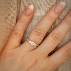 1,00 ct trilogy-timanttisormus sormessa pellavataustalla