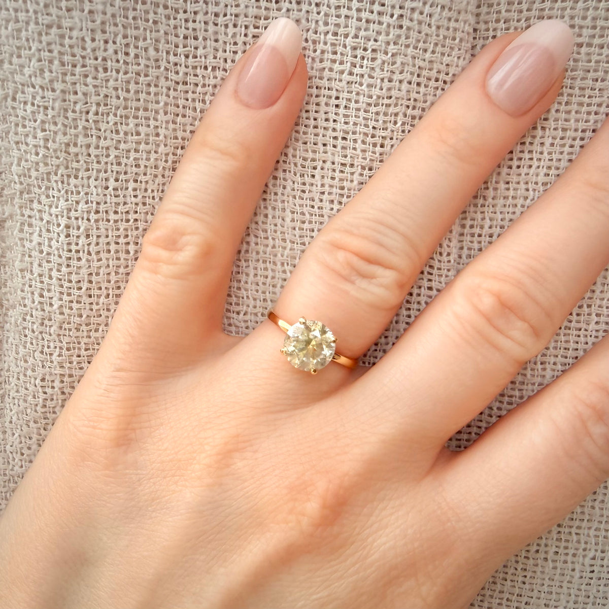 Luonnontimanttisormus noin 2,51 ct – Solitaire – 18K keltakulta sormessa pellavataustalla