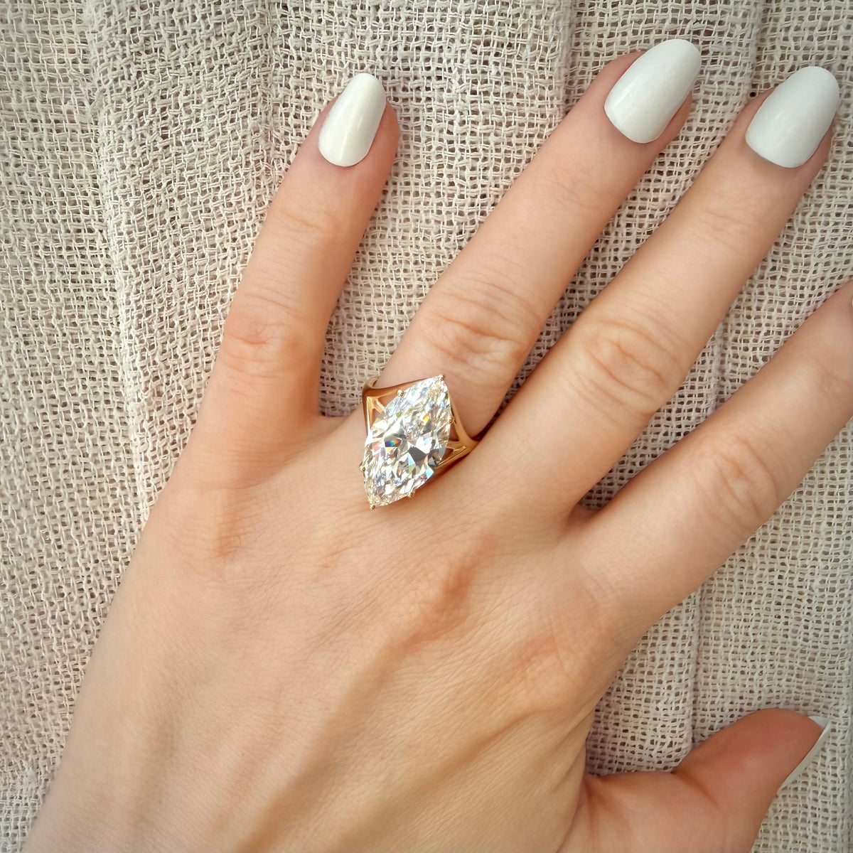 10,09 ct Marquise Cut -timanttisormus sormessa pellavataustalla kauempaa