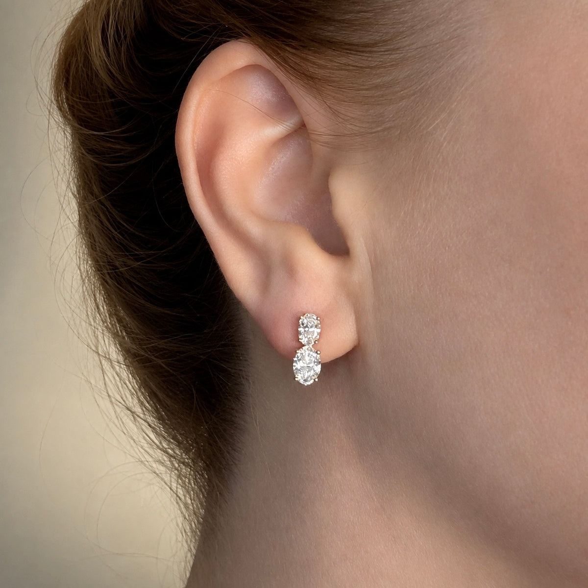 2,23 ct liikkuvat ovaalitimanttikorvakorut korvassa 