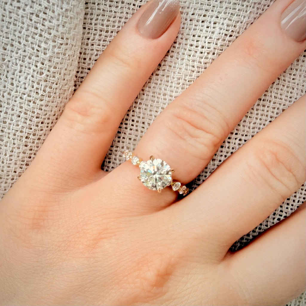 3,00 ct Hidden Halo -timanttisormus – 2,06 ct E/VS1 Triple Excellent – 14K keltakulta – IGI Sormessa pellava taustalla 