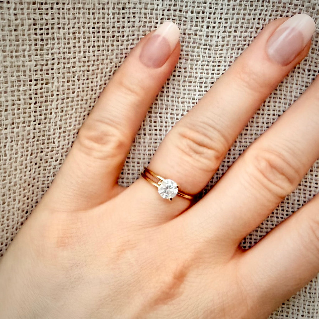 Solitaire 0,80 ct – luonnontimanttisormus, 14k keltakulta sormessa pellavataustalla
