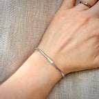 18K valkokultainen joustava mesh-rannekoru – Made in Italy ranteessa pellavataustalla