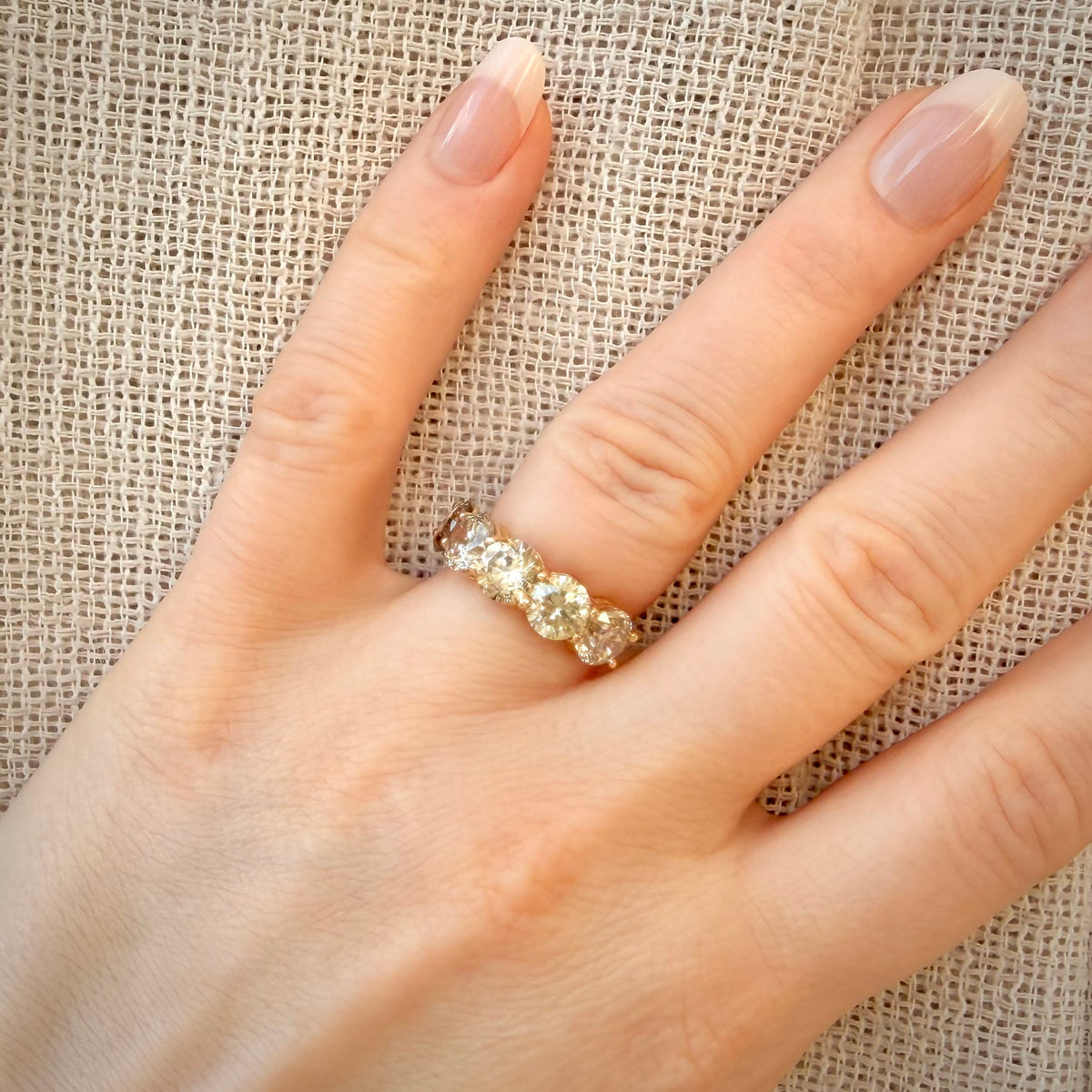 5,29 ct timanttisormus, 5-stone warm Champagne rivimalli sormessa pellavataustalla