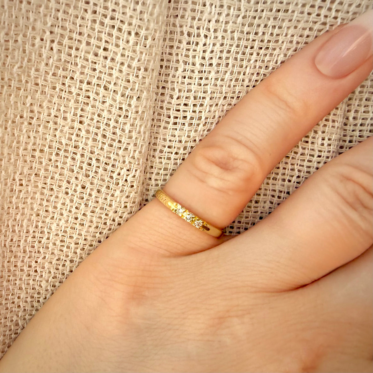 Vintage-timanttisormus kolmella timantilla – 14K keltakulta sormessa pellavataustalla