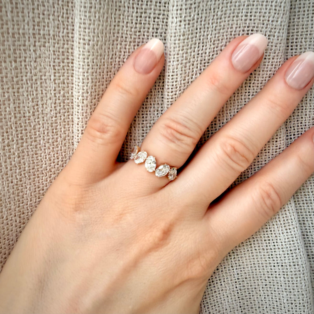 2,47 ct viisikivinen ovaalitimanttisormus – D–E/VVS – 14K keltakulta – HRD sormessa pellavataustalla