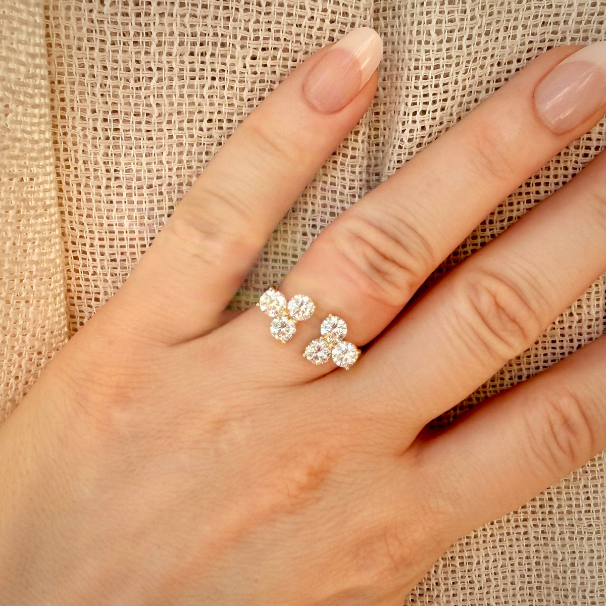 Timanttisormus 2,13 ct:n Luxury Cluster 14k keltakulta sormessa pellavataustalla
