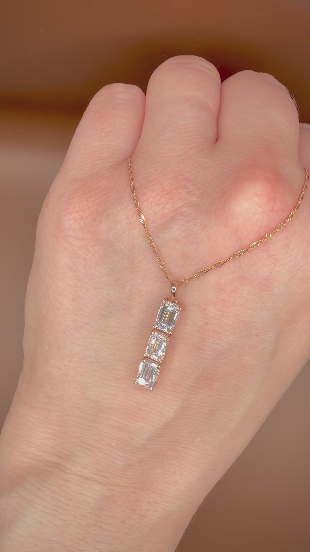 2,00 ct Emerald Cut -timanttikaulakoru kämmenselän päällä videolla