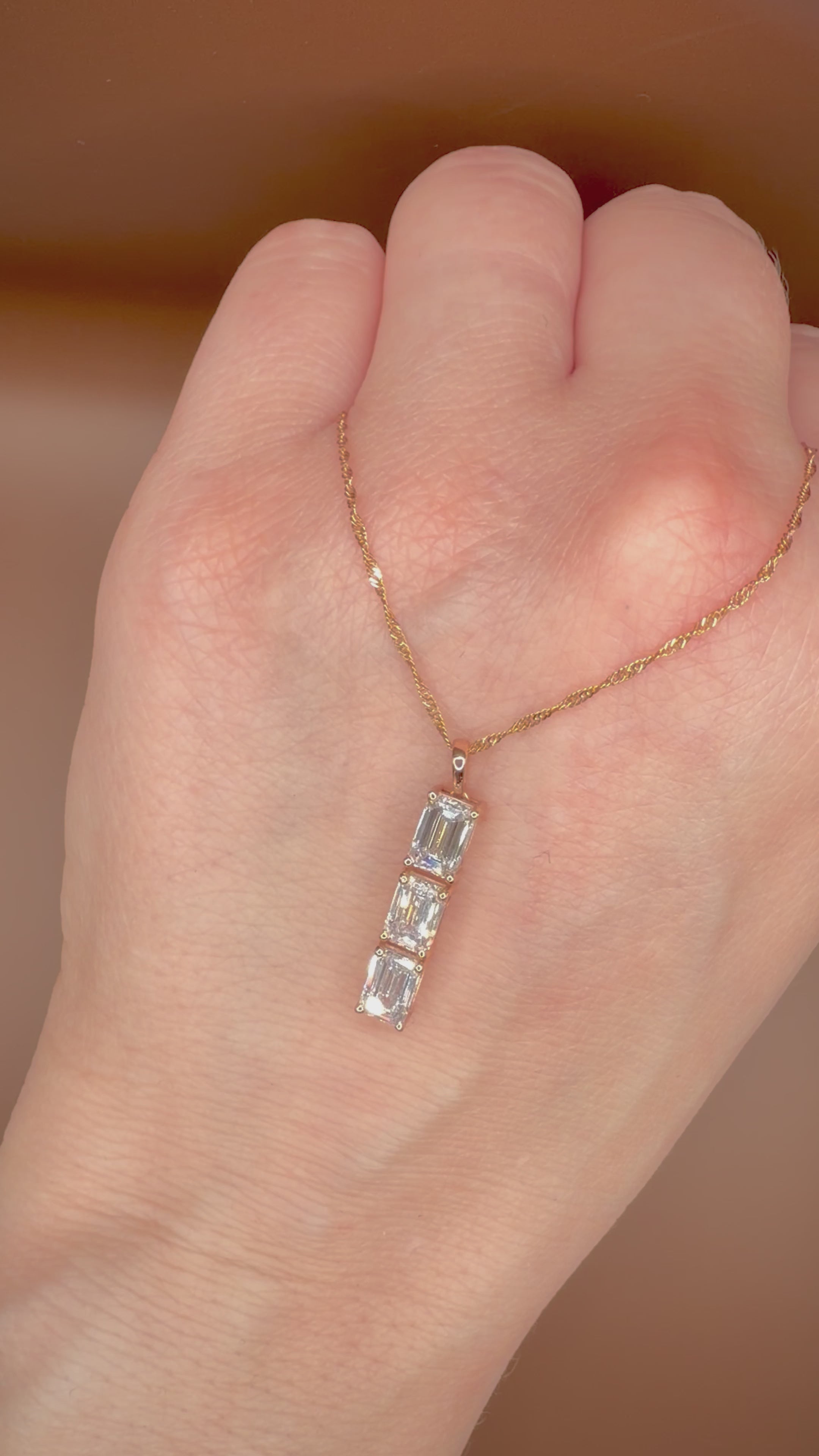 2,00 ct Emerald Cut -timanttikaulakoru kämmenselän päällä videolla