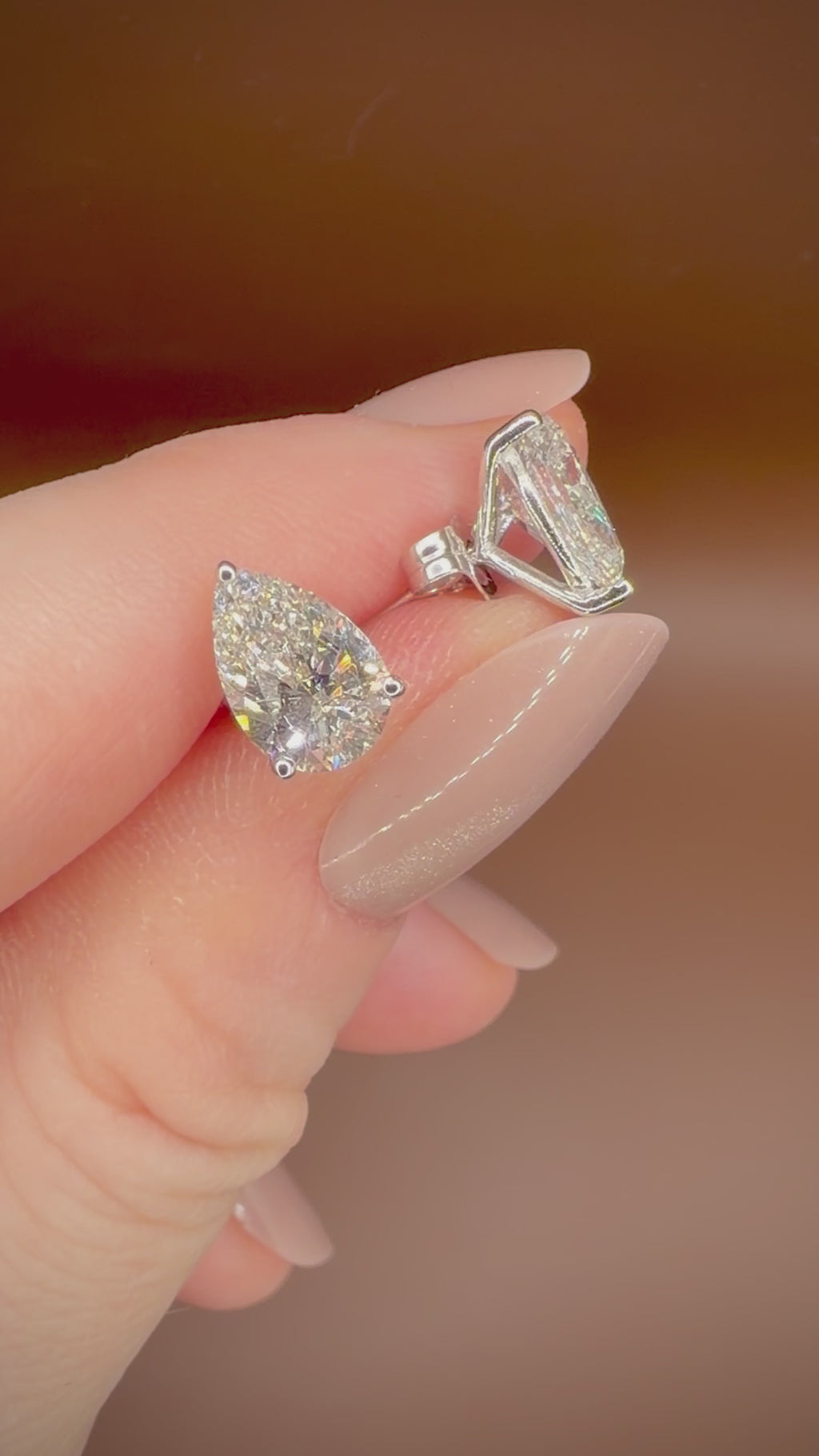 3,00 ct Pear Cut -timanttikorvakorut kädessä videolla