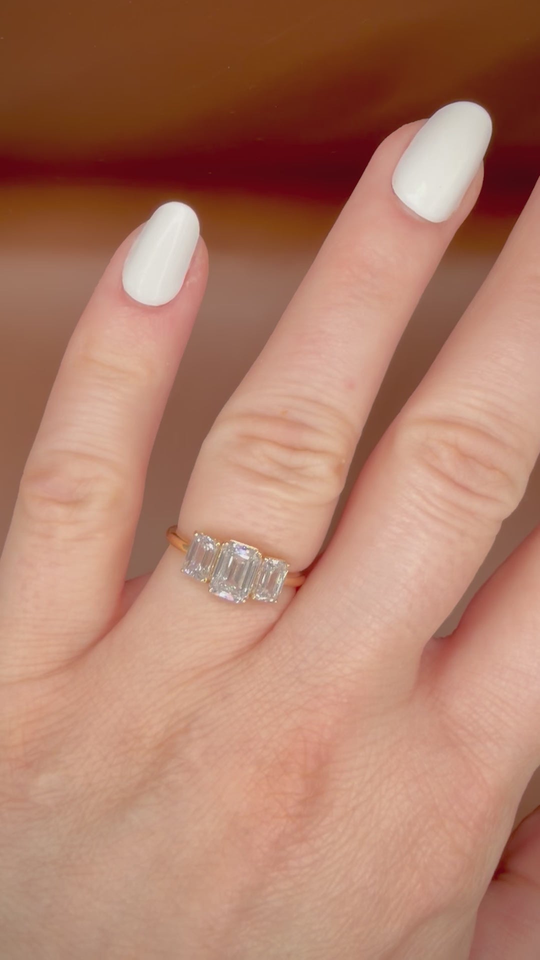 2,36 ct Emerald Cut trilogy-timanttisormus 14K | HRD video sormuksesta sormessa